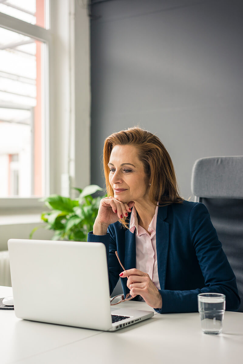 businesswoman-sitting-in-office-working-on-laptop-learning-microsoft-word